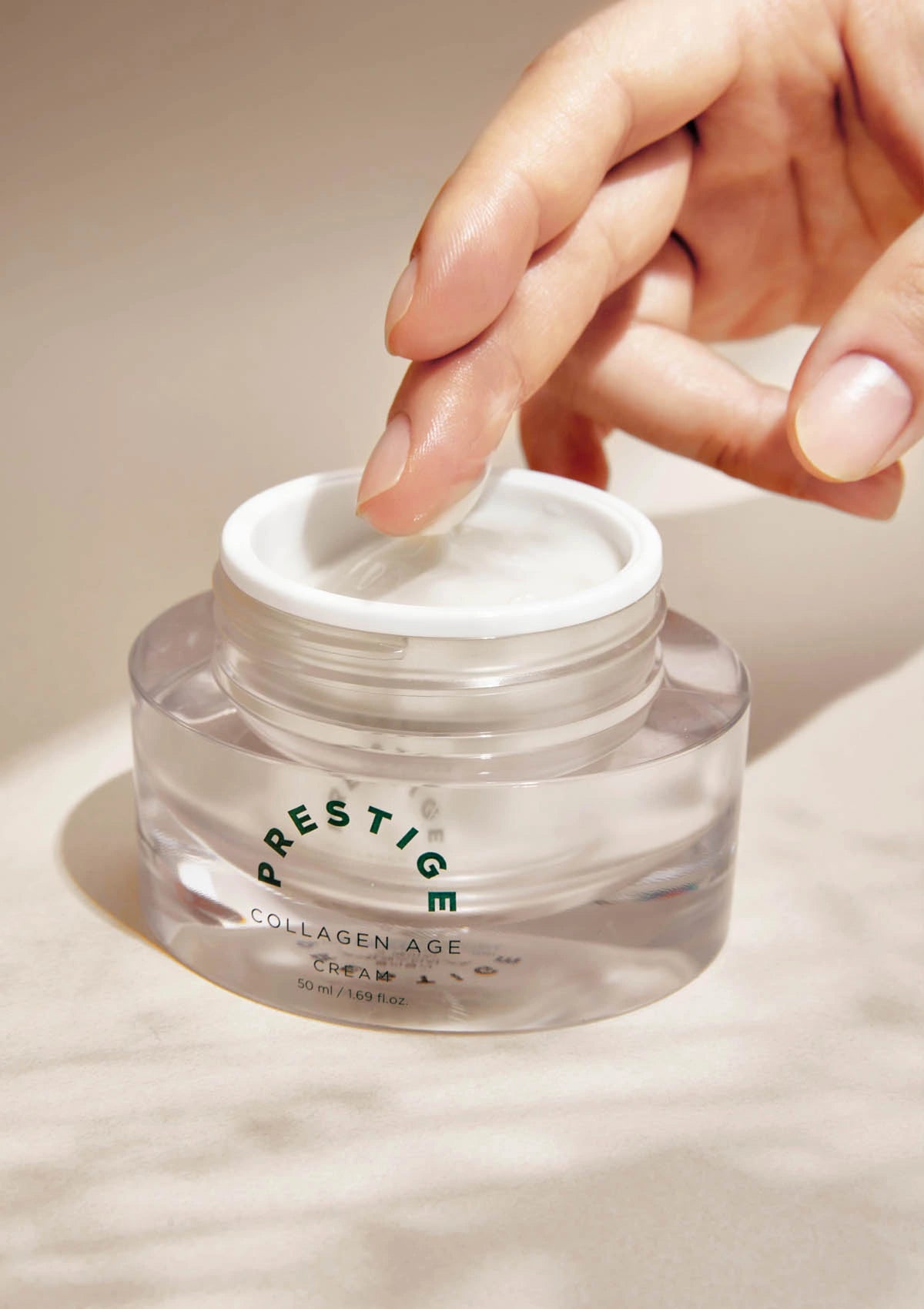 Hand opening a jar of Prestige Collagen Age cream on a neutral background